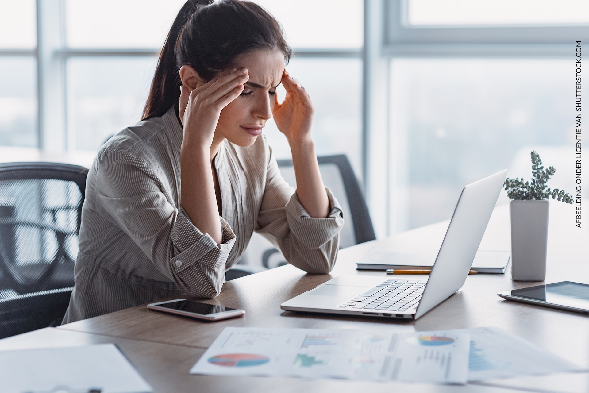Vrouw met werk-Stress zittend aan haar bureau in Groningen 