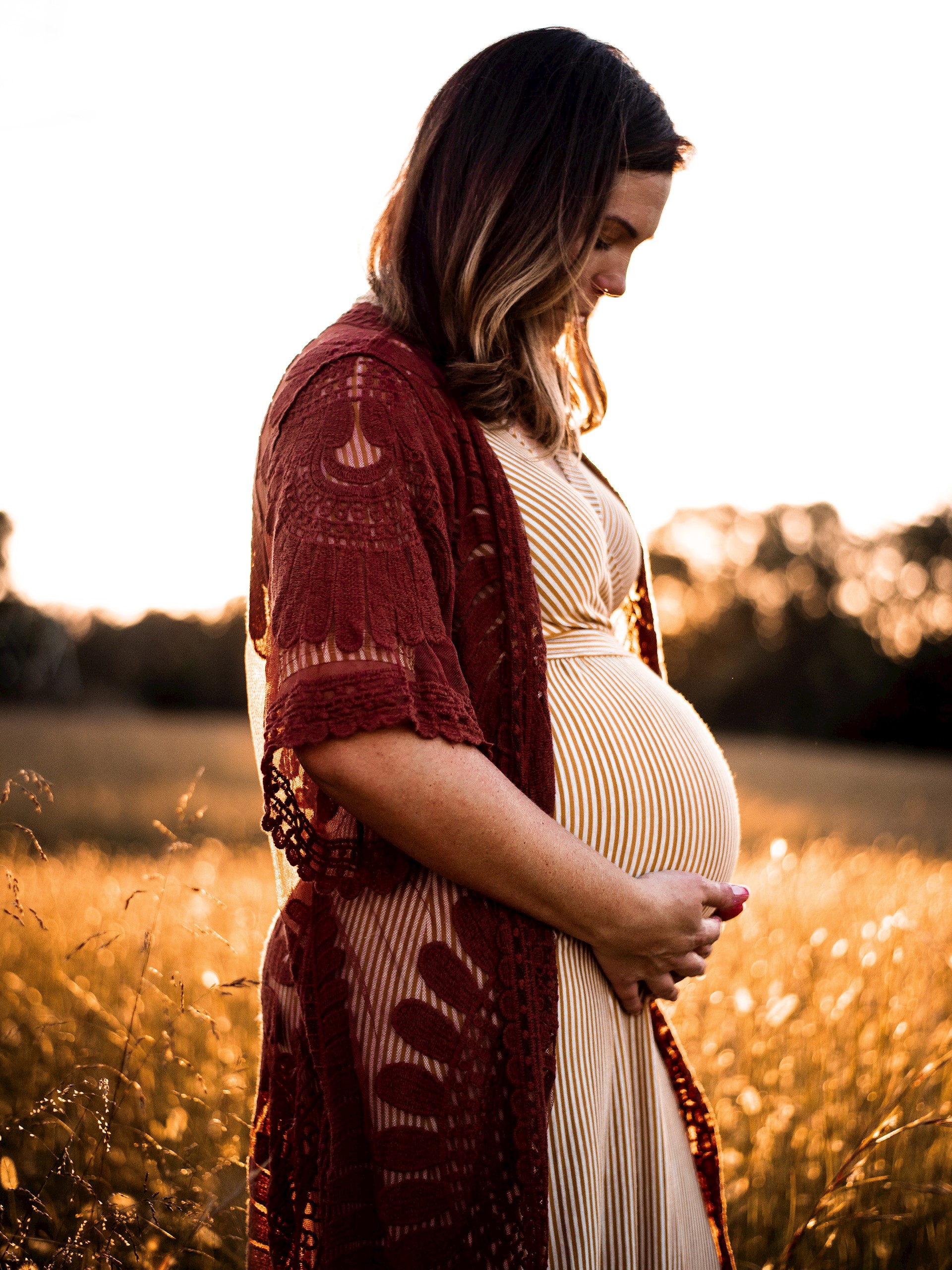 Profiel van een zwangere vrouw die haar buik liefdevol vasthoudt 
