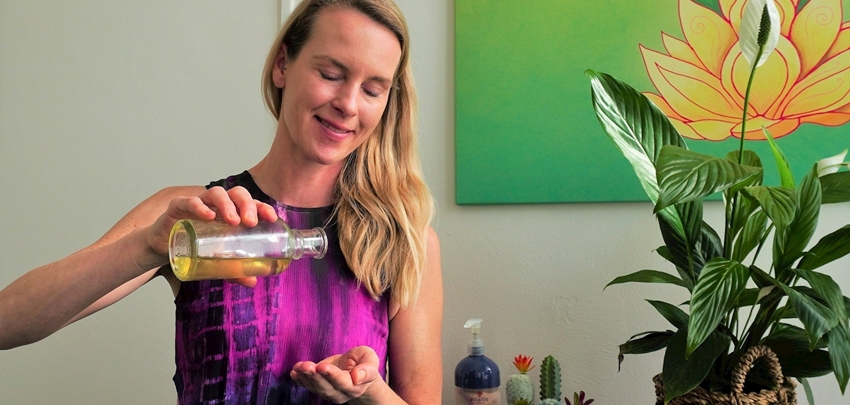 Jannet Veenbaas giet olie in haar hand voor een holistische massage Jannet Veenbaas giet olie in haar hand voor een holistische massage